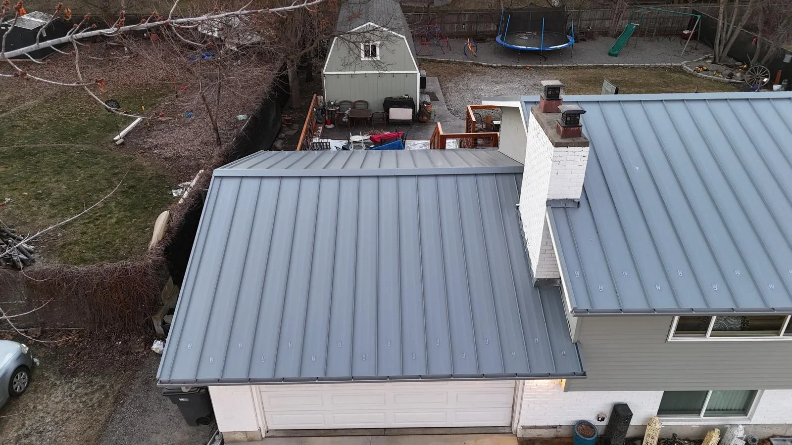 Standing seam metal roof with vertical seams on residential garage addition