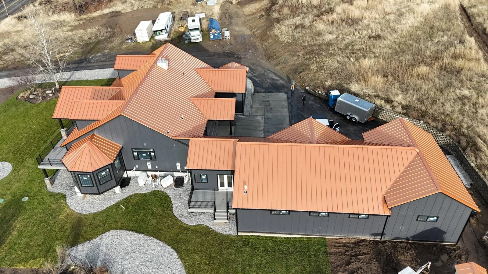 Copper standing seam metal roof with multiple pitched sections on residential home