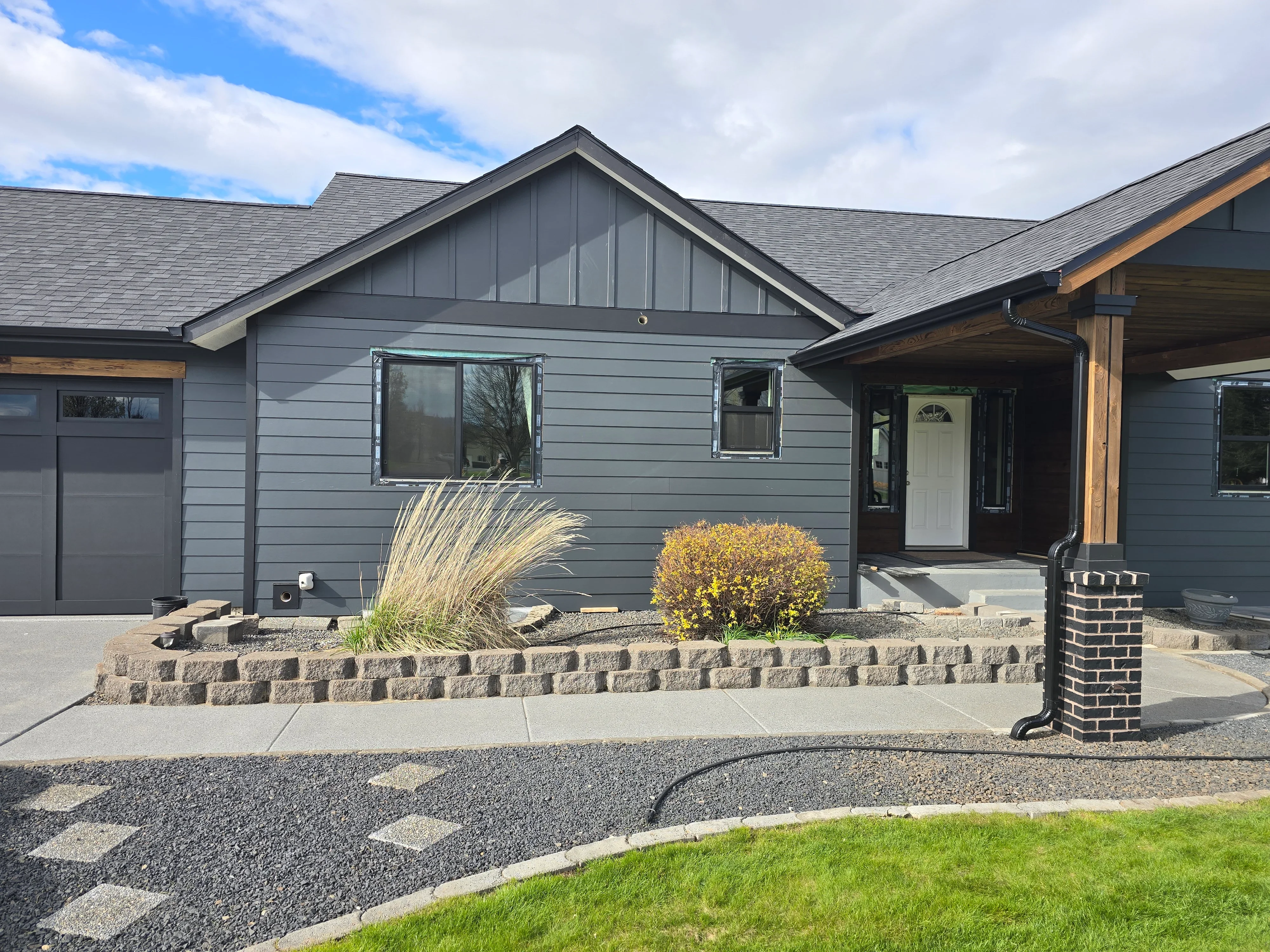 Gray architectural shingle roof with gable design on modern home with gray siding