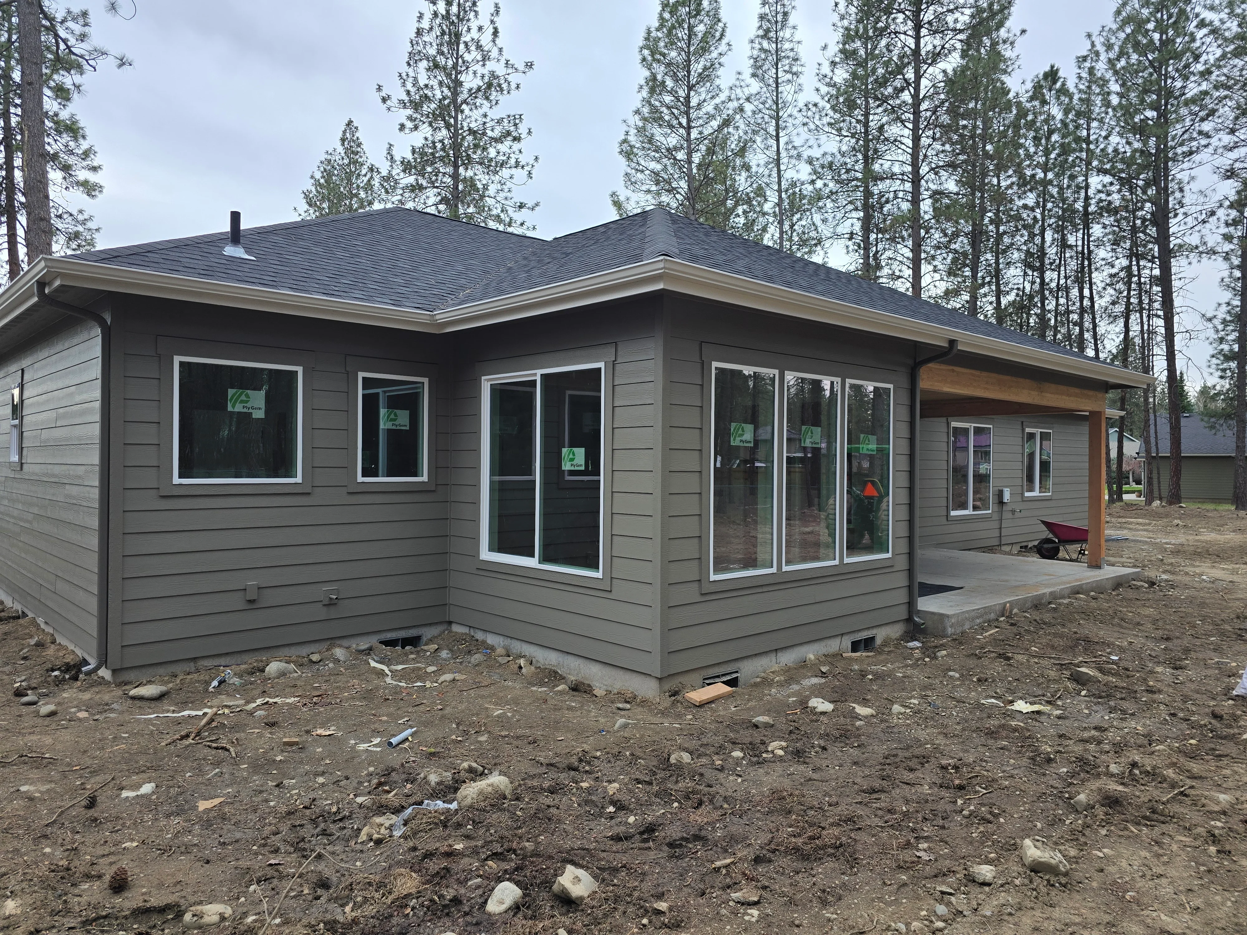 Dark architectural shingle roof on modern gray siding home with white trim windows