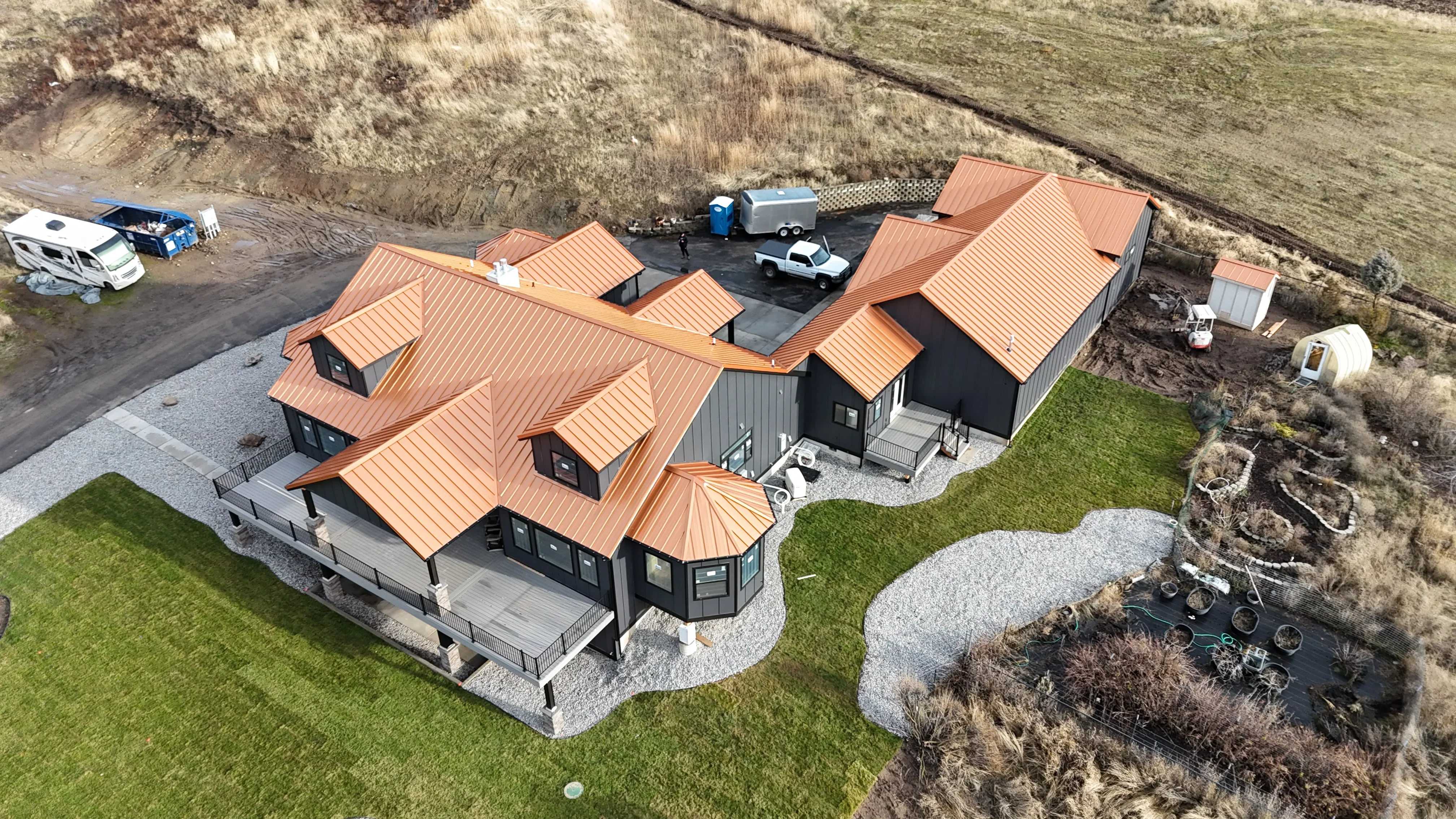 Copper metal standing seam roof with multiple peaks and skylights on modern residential home