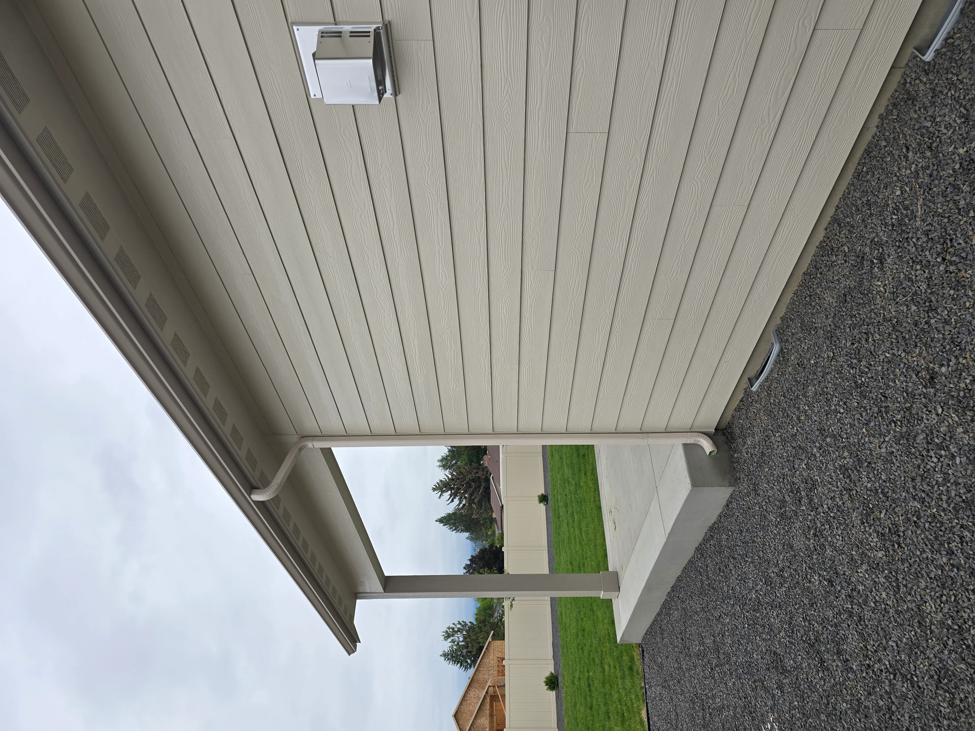 White vinyl soffit and fascia with integrated gutters and downspouts installed on residential home