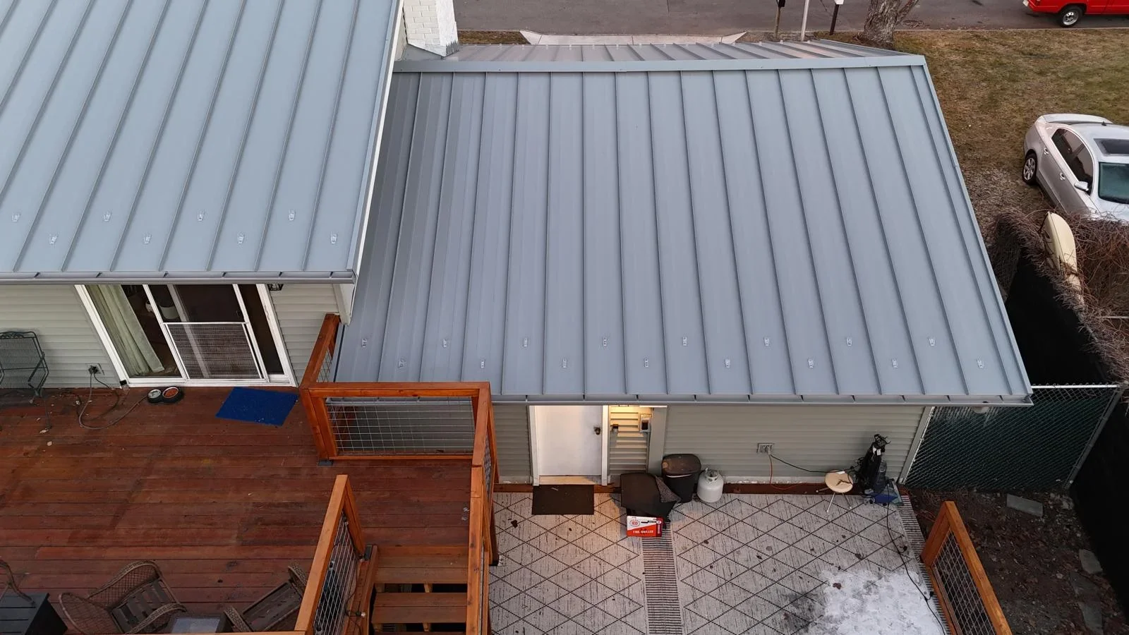 Gray standing seam metal roof with vertical panels and fasteners on residential home